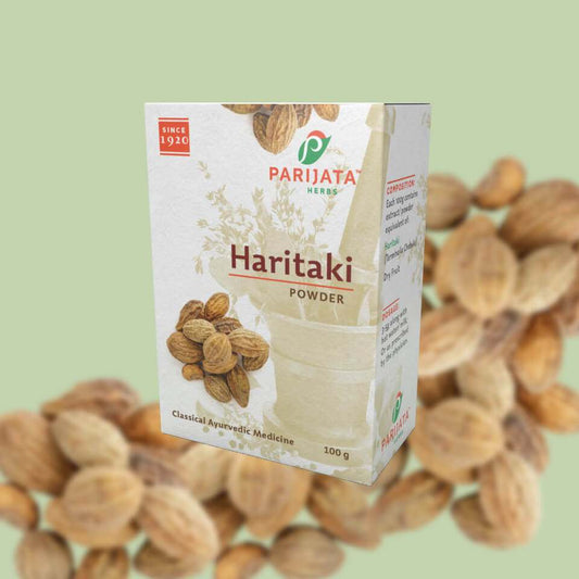 Parijata Herbs Haritaki Powder packaging against a background of Haritaki fruits.