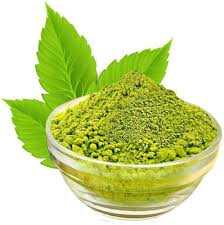 Parijata Herbs Tulasi Leaf Powder in a glass bowl with green leaves.
