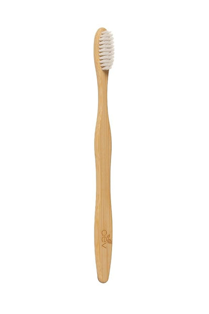 Eco-friendly toothbrush next to mint leaves and toothpaste