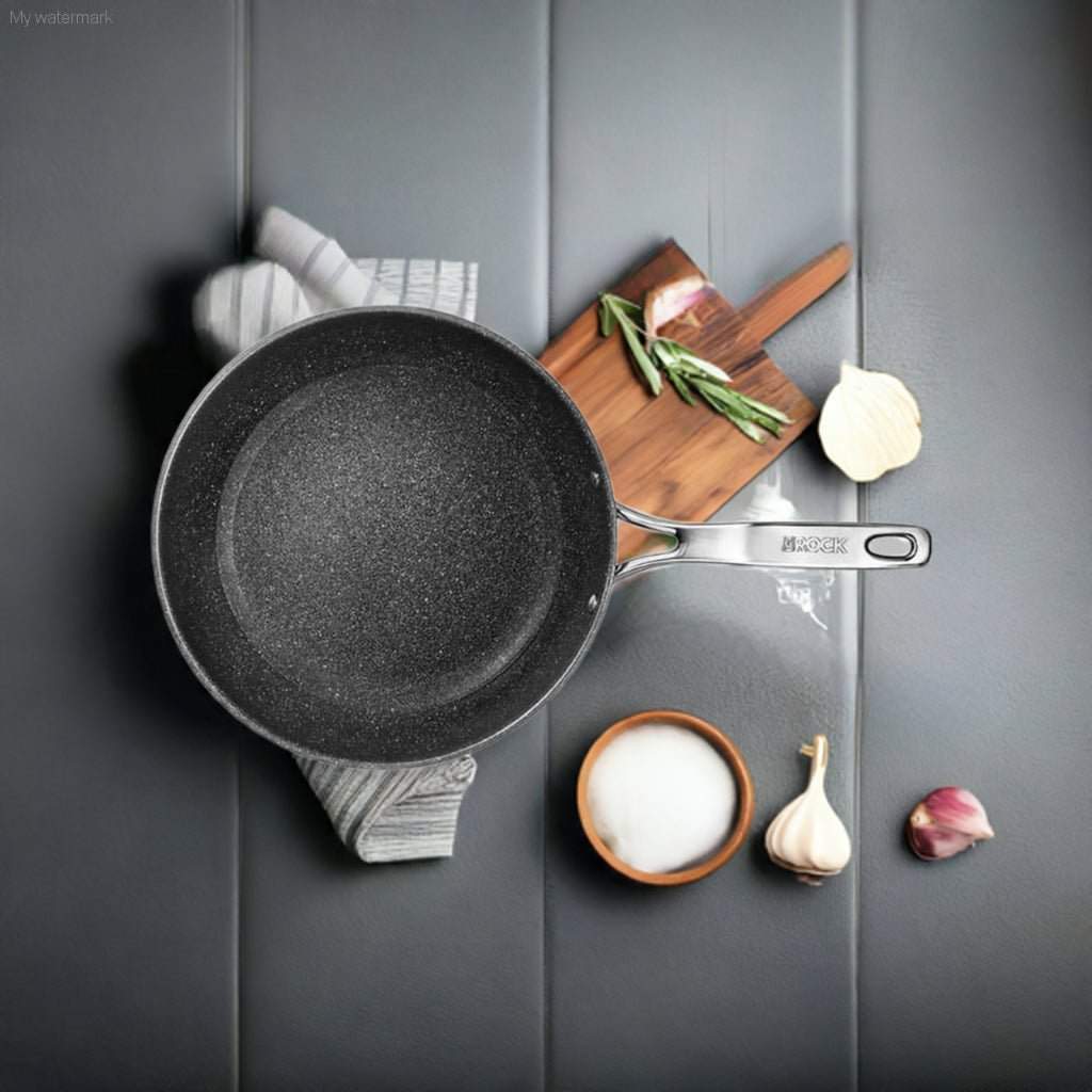 SUTRA Fry Pan with strong handle on a cooking surface, surrounded by ingredients.